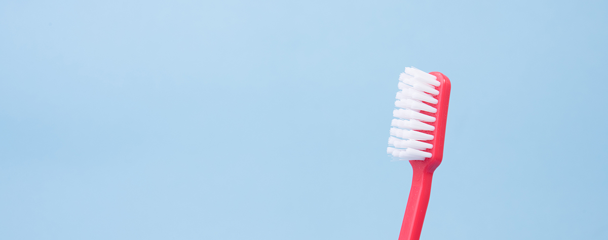 A close up of a soft bristled red toothbrush.